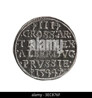 Trojak, Schilling; Maciej Schilling Münzmeister; Mitschöpfer: Jost Ludwik Decjusz fl. 1528–1535; MINT Manager. Vorderseite: Männliche Büste in Rüstung im Profil nach rechts; kurzes Haar, langer Bart mit Koteletten; Randbeschriftung beginnend mit einem Dreireifen: -ALBER DG MAR BRAN DVX PRVS; Perlenrand; Pflanzenmotive zwischen den Wörtern. Rückwärts: perlenrand mit sechszeiliger Inschrift: -III-/.GROSS:AR:/.TRIPLEX./.ALBER:DVC./.PRVSSIE./-1544-; Bezeichnung und Datum zwischen den Markierungen. Vom 1544. Ausgestellt für Herzogtum Preußen 1525–1701, Königsberg Münzprägeanstalt. Münze; Durchmesser 21,6 mm; Gewicht 2,81 g; Achse 220°, runde Metallmünze Stockfoto