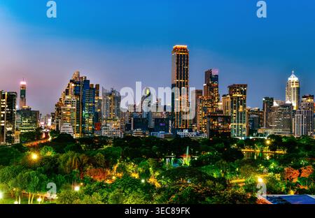 Skyline der Stadt Bangkok bei Nacht mit Grünflächen des Lumphini Parks vom Aussichtspunkt Dusit Central Park, Thailand. Stockfoto