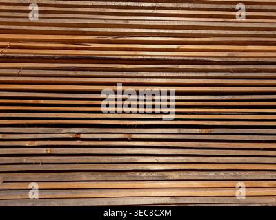 Detaillierte Ansicht von gestapelten dünnen Holzbrettern oder -Dielen im Sägewerk oder auf der Baustelle. Natürliche Holzmaserung und -Textur bei hellem Sonnenlicht. Industrie, Stockfoto