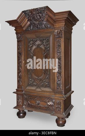 Garderobe, Provenienz, Putti; Barock; Wappen; Pflanzendekoration; Löwenmasken; Personifizierungen der Jahreszeiten: Frühling, Sommer, Herbst, Winter; 1710–1730; Gdańsk, Königlich Preußen; Möbelaufbewahrung; Höhe 200 cm, Breite 124 cm, Tiefe 62 cm, Ein großer kunstvoller Holzschrank steht vor einem hellgrauen Hintergrund, geschnitzt aus dunkelbraunem Holz mit satter Maserung. Der Schrank verfügt über ein überhängendes Gesims mit Stufenleiste und ein kunstvoll geschnitztes Wappen mit Blumen- und Blättermotiven. Die Mitteltür hat eine vertiefte Platte mit symmetrischen geschnitzten Ornamenten, einschließlich geschwungener Bogenformen Stockfoto