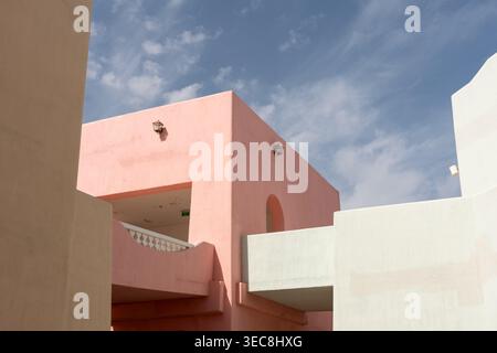 Ein flaches architektonisches Bild des Mina District in Katar mit klaren Linien von rosa, weißen und pfirsichfarbenen Gebäuden und traditionellen Laternen. Stockfoto