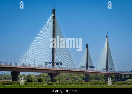 Die beeindruckende Mersey Gateway Bridge steht hoch und verbindet Runcorn und Widnes. Sonnenlicht reflektiert von den Kabeln und schafft einen bezaubernden Anblick als Auto Stockfoto