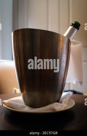 Flasche gekühlten Sekt in einem Eiskübel auf einem mit Leinen gefütterten Teller, geliefert als Zimmerservice in einer Luxussuite im Bloomsbury Hotel in London Stockfoto