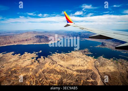 Flug über Lake Mead auf dem Weg nach Las Vegas in Nevada. Wunderschönes blaues Wasser, Canyons, Berge, Täler vom Flugzeug aus gesehen. Antennenansicht des Behälters. Stockfoto