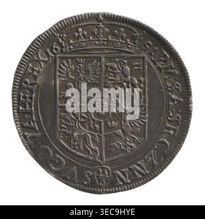 Krone Halbgrosz, Kasimir IV. Jagiellon (König von Polen; 1446–1492), 1456–1492, Kraków, Münze, Gewicht 0,82 g, Eine kreisförmige Metallic-Münze mit dunkelbrauner und grauer Patina, die Verschleiß und erhöhtes Relief zeigt. Im Zentrum befindet sich ein großes Schild, das in Abschnitte mit verschiedenen geprägten Tier- und Heraldenformen unterteilt ist, flankiert von ornamentalen Details. Über dem Schild befindet sich eine dekorative Krone mit kleinen floralen Elementen. Der Rand ist strukturiert mit einem wiederholten Kantenmuster, und die Oberfläche weist Kratzer, Dellen und Bereiche mit hellerer und dunklerer Färbung auf. Stockfoto