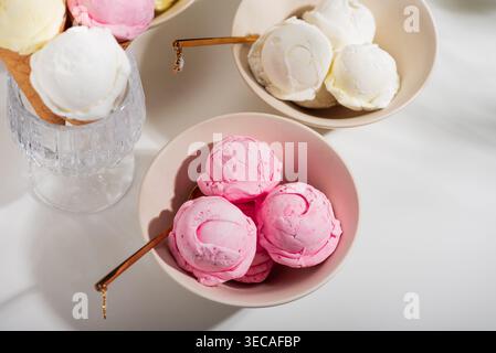 Helle Gourmet-Komposition mit drei Schüsseln Eis in verschiedenen Geschmacksrichtungen: Erdbeere mit frischem Obst, Vanille oder Kokos mit Minzblättern, Stockfoto