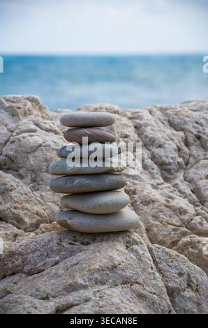 Gestapelte glatte Steine an der Küste von Rocky Beach Stockfoto