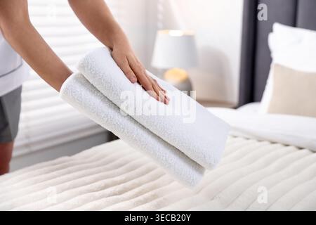 Frau, die Handtücher aus dem Bett nimmt, Nahaufnahme Stockfoto