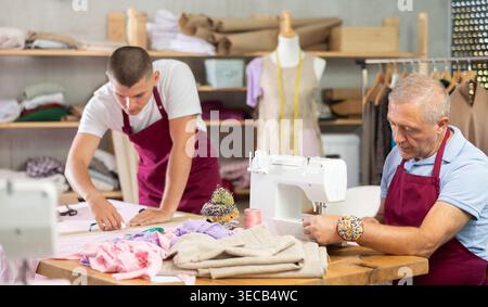 Älterer Mann näht auf Maschine männliche Assistenten Zeichenmuster Stockfoto