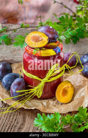 Hausgemachte Pflaumenmarmelade in einem Glas mit Schleife und frischen Pflaumen Stockfoto