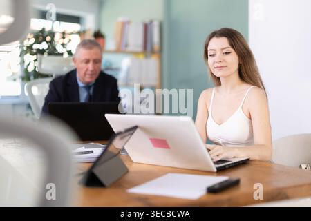 Älterer Mann und junge Frau im Büro Stockfoto