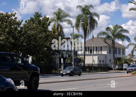 Buena Park, Kalifornien, USA - 11. April 2026: Nachmittags passiert der Verkehr historische Bauten und die Uhr entlang des Beach Blvd. Stockfoto