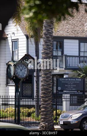 Buena Park, Kalifornien, USA - 11. April 2026: Nachmittags passiert der Verkehr historische Bauten und die Uhr entlang des Beach Blvd. Stockfoto