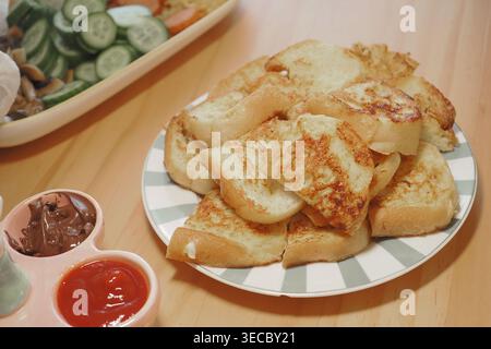 Stapel gerösteter Brotscheiben auf Teller mit Dips und Salat zum Frühstück oder Snack Stockfoto