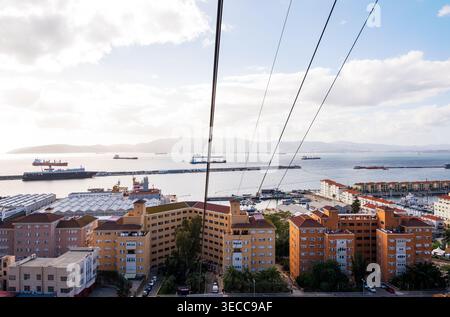 Ein Panoramablick über den Hafen von Gibraltar mit modernen Wohngebäuden im Vordergrund, mehreren Frachtschiffen und Tankern Stockfoto