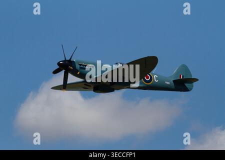 Ein Supermarine Spitfire fliegt anmutig über den Himmel der Fairford Landschaft. Stockfoto
