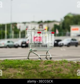Einzelner Einkaufswagen auf leerem Parkplatz Stockfoto