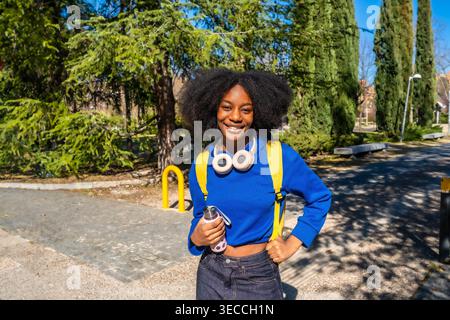 Junger afroamerikanischer Student lächelt auf dem Universitätsgelände Stockfoto