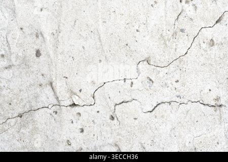 Vorderansicht Makroaufnahme eines tiefen diagonalen Risses in einer verwitterten Betonwand Stockfoto