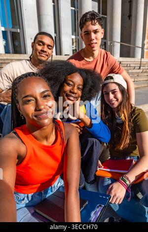 Verschiedene Studenten machen Selfie auf der Treppe des Universitätsgeländes Stockfoto