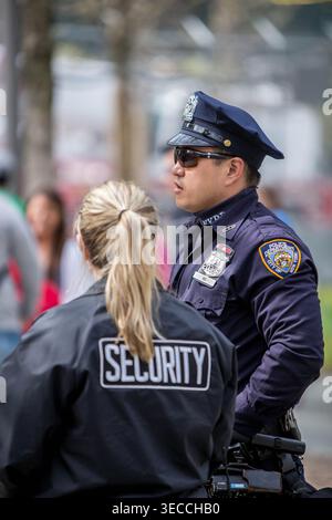 Ein NYPD-Offizier und ein privater Sicherheitsbeamter stehen zusammen im Dienst während einer öffentlichen Veranstaltung in New York City und demonstrieren städtische Sicherheitsmaßnahmen Stockfoto