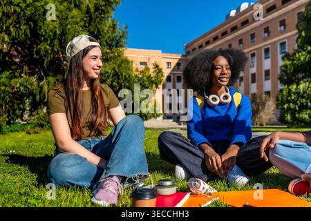 Vielfältige Studenten, die sich auf dem Universitätscampus entspannen und gemeinsam lernen Stockfoto