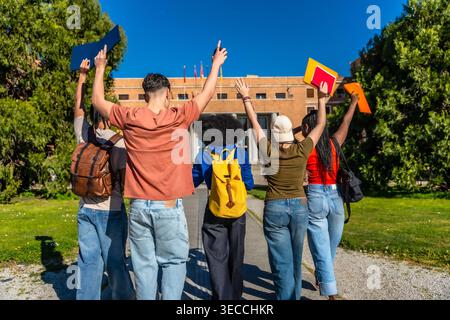 Gruppe von Studenten, die erfolgreich auf dem Universitätscampus ihren Abschluss feiern Stockfoto