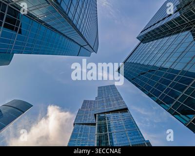 Hoch aufragende Glasfassaden moderner Wolkenkratzer erstrecken sich in Richtung eines klaren blauen Himmels in Moskau-Stadt Stockfoto