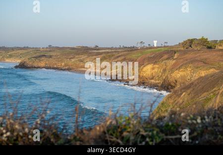 Malerische felsige Küste mit Meereswellen und Klippen unter klarem Himmel in Küstenlandschaft Stockfoto