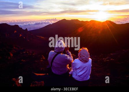 Auf dem Gipfel des Haleakala Berges können Sie den Sonnenaufgang genießen und dann mit dem Fahrrad auf Maui Island, Hawaii, USA, zum Meeresspiegel fahren Stockfoto