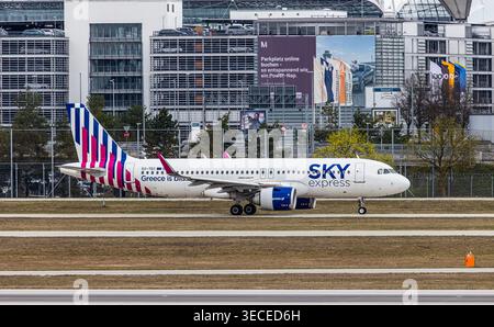 München, 4. April 2026: Ein Airbus A320-251N (Airbus A320neo), der von Sky Express Greece betrieben wird, fährt zur Start- und Landebahn am Flughafen München. Registrierung Stockfoto