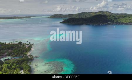 Wenn Sie Bora Bora aus der Vogelperspektive betrachten, entdecken Sie atemberaubendes türkisfarbenes Wasser, lebendige Korallenriffe und üppige Inseln unter einem bewölkten Himmel, die ein tropisches Paradies schaffen Stockfoto