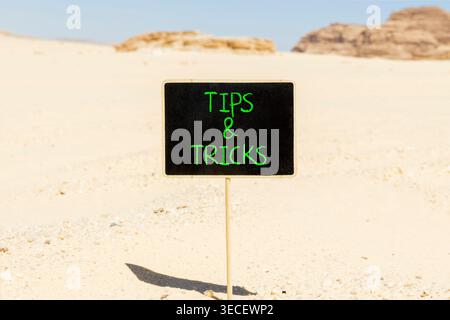 Symbol für Tipps und Tricks. Konzeptworte Tipps und Tricks auf der schönen Tafel. Wunderschöner Sand im Hintergrund der Sinai-Wüste. Geschäftliche Tipps und Tricks Stockfoto