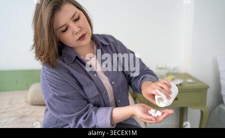 Medikament plus Größe Frau, die Pillen aus der Flasche zu Hause, Gesundheitsroutine, verschreibungspflichtige Behandlung, psychische Gesundheit, Apotheke, Selbstversorgung. Stockfoto