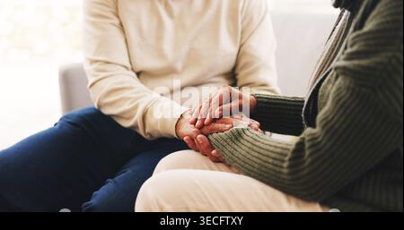 Hände halten, Liebe und Unterstützung mit dem alten Paar zu Hause für Empathie, Verbindung und Vertrauen. Eheschließung, Freundlichkeit und Loyalität gegenüber Senioren Stockfoto