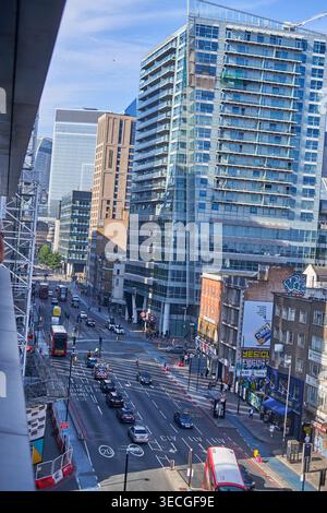 Luftbild einer belebten Kreuzung in London, UK, das einen auffälligen Kontrast zwischen historischen Backsteingebäuden und modernen Glas-Hochhäusern zeigt. Die Stockfoto