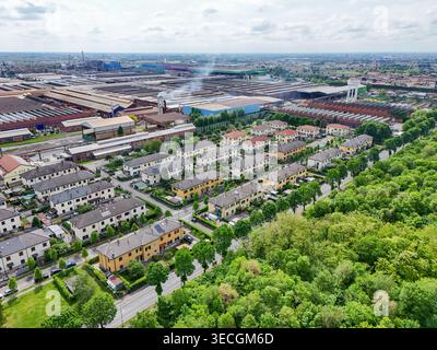 Luftaufnahme des Industriekomplexes und Wohnviertels mit Häuserreihen und grünen Bäumen in Dalmine, Lombardei, Italien. Stockfoto