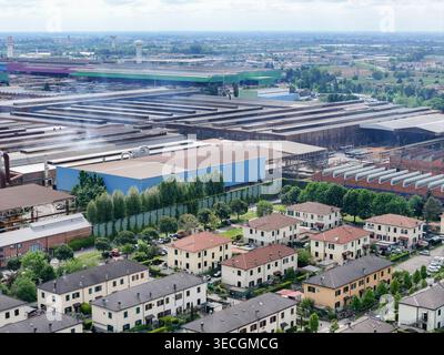 Luftaufnahme des Industriekomplexes und Wohnviertels mit Häuserreihen und grünen Bäumen in Dalmine, Lombardei, Italien. Stockfoto
