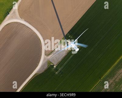 Luftaufnahme der Keadby Wind Farm mit einer einzigen Turbine, die einen langen Schatten über grüne und braune landwirtschaftliche Felder wirft Keadby, England, Großbritannien. Stockfoto