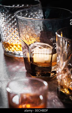 Eleganter Bourbon auf Eis in strukturiertem Tumbler mit Kristallhintergrund Stockfoto