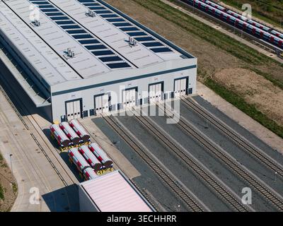Aus der Vogelperspektive der Siemens Mobility Eisenbahnfabrik mit Bahngleisen, Solarpaneelen auf dem Dach und geparkten Zugwagen in Goole, England, UN Stockfoto