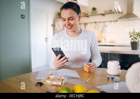 Eine Frau macht und malt einen Keramikbecher. Stockfoto