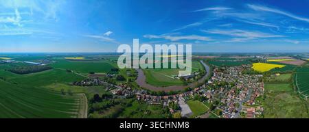 Aus der Vogelperspektive eine Panoramalandschaft mit dem Dorf Airmyn neben einem gewundenen Fluss und gelben Rapsfeldern in Airmyn, England, United King Stockfoto