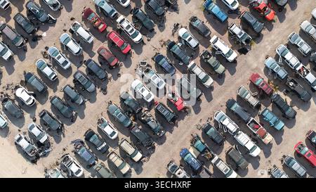 DALLAS, TX, USA - 17. November 2025: Luftaufnahme eines großen Schrottplatzes mit Reihen von unglückten und ausrangierten Fahrzeugen Stockfoto