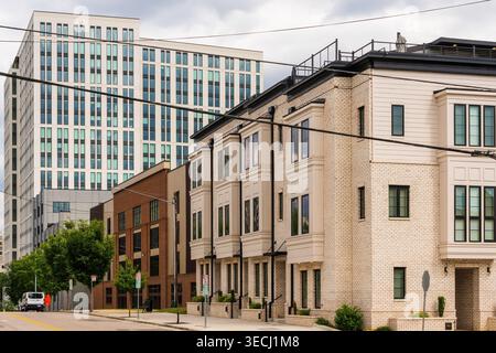 Raleigh, North Carolina, USA – Mai 2026: Neu gebaute Luxusstädte säumen die Lenoir Street mit dem Maeve-Hochhaus im Hintergrund. Stockfoto