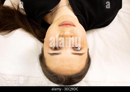 Ein Bild einer sehr schönen und attraktiven jungen Dame, die den Prozess der Lippeninjektion und Verjüngung zeigt, in einem professionell gestalteten Büro Stockfoto
