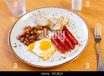 Chistorra-Wurst mit Spiegelei und Bohnen Stockfoto