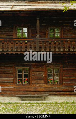 Rustikaler Village-Charme. Altmodisches Cottage In Den Tschechischen Bergen Mit Blumen Und Geschnitzten Holzarbeiten Stockfoto