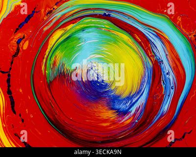 Lebendige abstrakte Acrylmalerei mit wirbelnden konzentrischen Ringen in Rot, Gelb, Grün und Blau. Dynamische Pinselstriche sorgen für eine kräftige, farbenfrohe Farbe Stockfoto