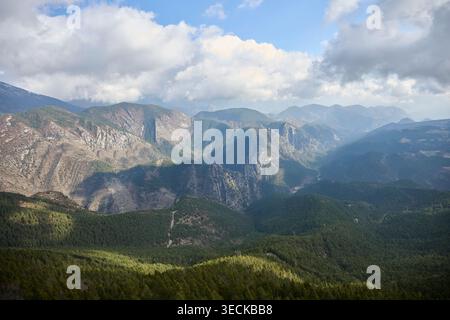 Panoramablick auf die Berge Cadi-Moixero im Winter, mit schneebedeckten Gipfeln, geschichteten Tälern und Kiefernwäldern unter dramatischen Wolken und en Stockfoto